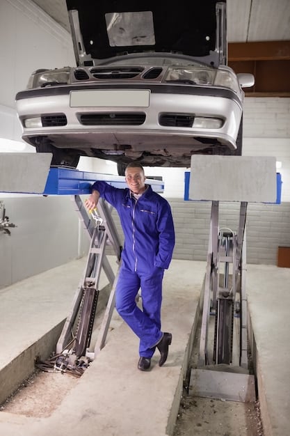 An image showing a mechanic inspecting the undercarriage of a car on a lift. The mechanic is pointing to a specific component, likely related to the recall issue. The lighting is bright, highlighting the details of the car's mechanics.